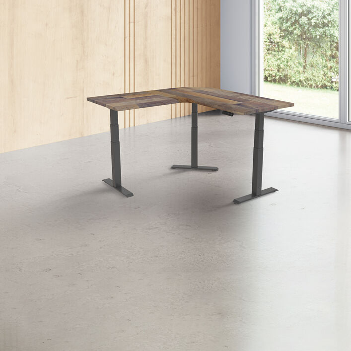 L-shaped standing desk with three legs in a bright room with a slatted wood wall, a large window with greenery outside, and a concrete floor. image number 0